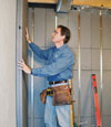 Insulated basement wall panels being placed against a concrete foundation wall in Millville