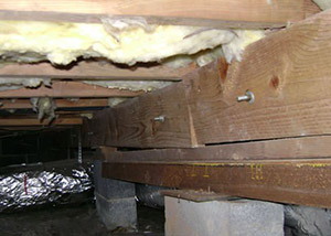 A sagging crawl space with concrete supports and wooden shimming a Egg Harbor Township crawl space