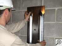 Mounting a foundation wall plate for an earth anchor installation in Millville.