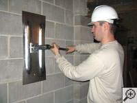 Attempting to straighten a bowed foundation wall by straightening a wall anchor system in a Absecon home.