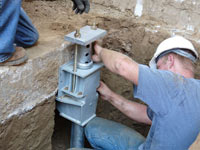 Foundation repair contractors installing the foundation bracket in Clementon.