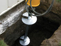 Installing a helical pier system in the earth around a foundation in Bridgeton
