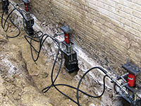 Using foundation push piers to lift a foundation during a repair in Marlton.