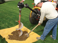 Auguring a hole in the earth for a foundation wall repair system in Absecon