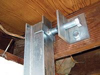 Securing the i-beam system to the top of the floor joist in a foundation wall repair in Absecon.