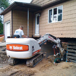 Excavating to expose the foundation walls and footings for a replacement job in Millville