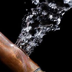 A bursting copper pipe in Bridgeton, with water gushing out.