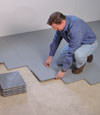 Contractors installing basement subfloor tiles and matting on a concrete basement floor in Blackwood, New Jersey and Pennsylvania